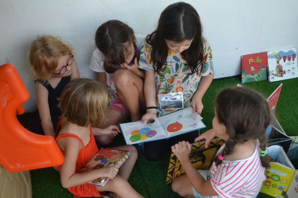 Activité de lecture animée par les plus grands pour les plus petits.